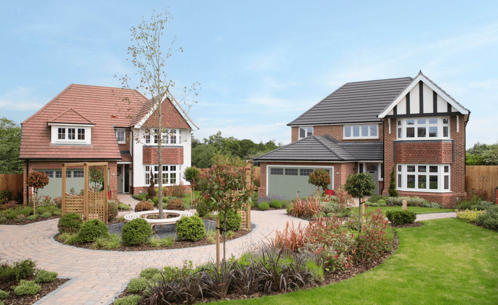 Two detached brick-built new-build houses with landscaped front gardens and a circular paved path