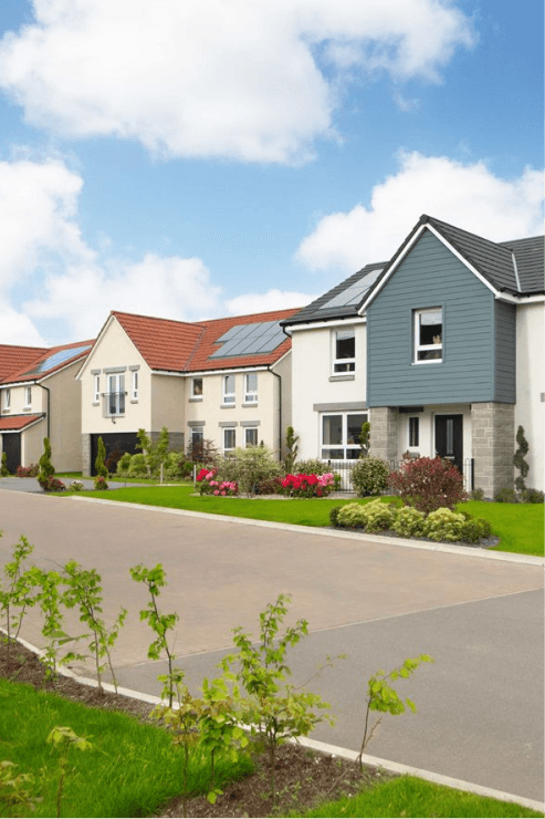 Modern new-build houses in the UK with red tile and grey slate roofs, solar panels, and landscaped front gardens